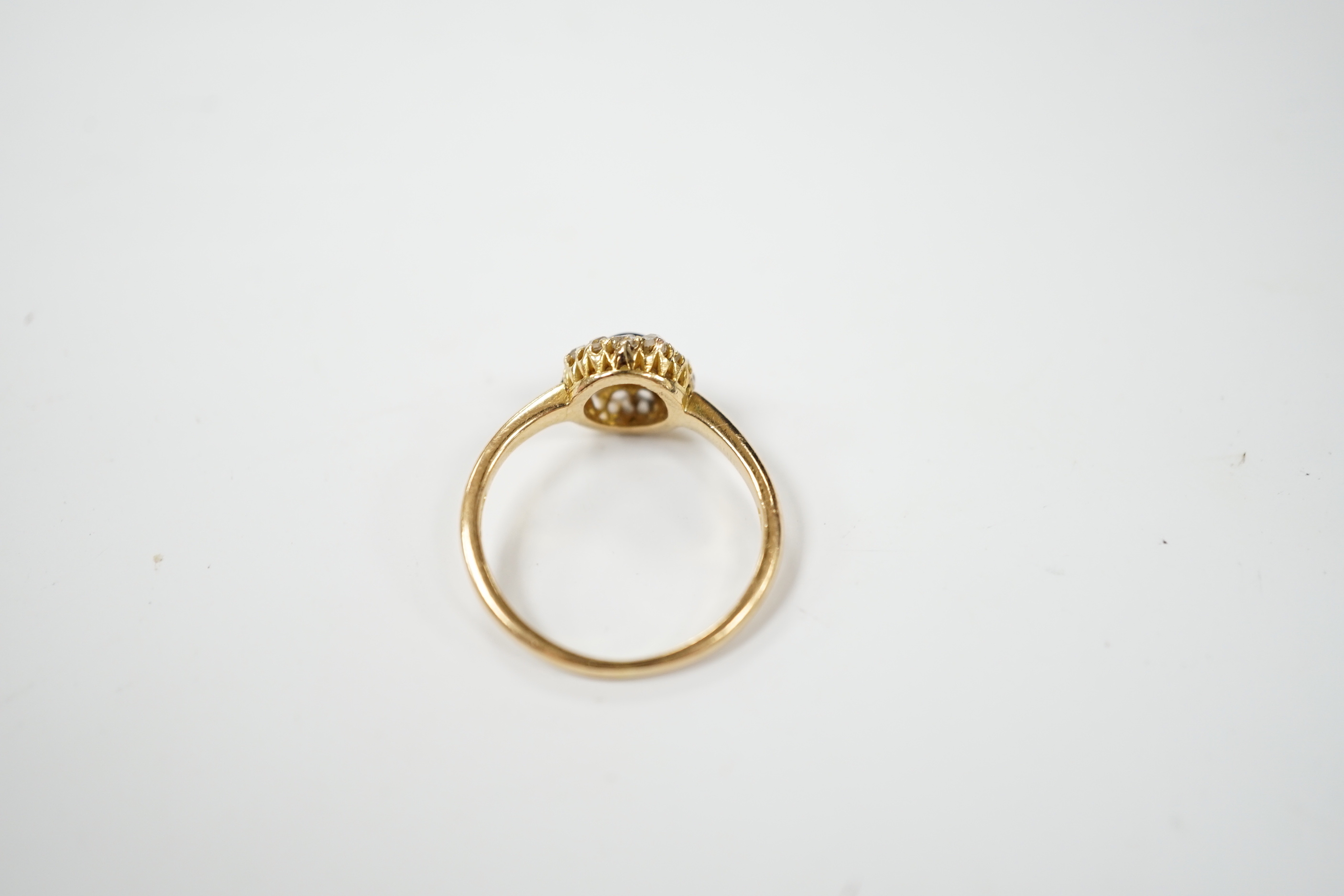 An 18ct, foil backed cabochon and diamond cluster set dress ring, by Annina Vogel, size M/N, gross weight 2.7 grams.